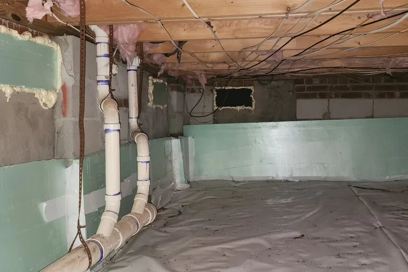 Sloppy, incomplete foam board wall insulation with gaps and messy spray foam in a crawl space in NC