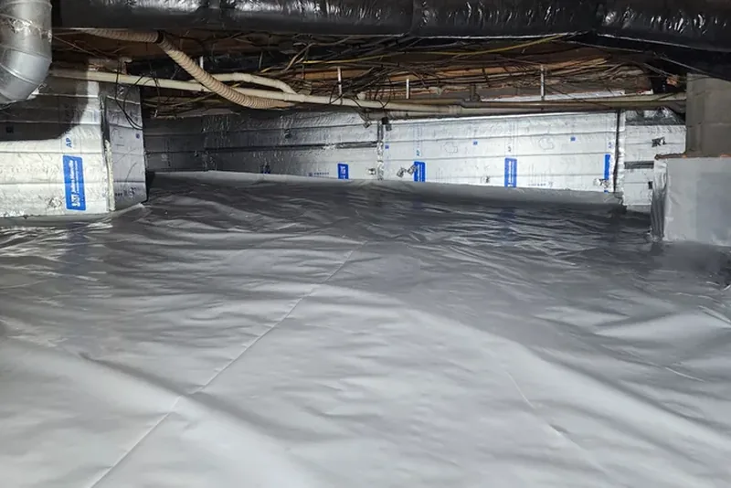Sealed crawl space after encapsulation — foil-faced rigid foam wall insulation, sealed piers, conditioned ductwork, and a continuous white vapor barrier across the floor in a Wake County NC home