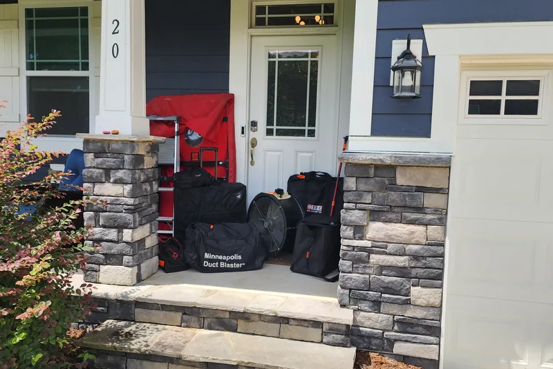 Peak Energy blower door, duct blaster, and testing equipment staged on the front porch of a Triangle NC home before a home energy audit