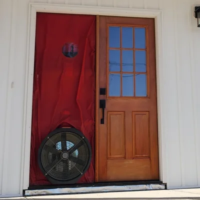 Blower door fan installed in front entry from exterior view during NC air leakage test