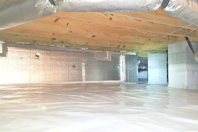 Completed crawl space encapsulation with white vapor barrier installed in a Holly Springs NC home